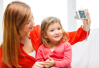 Image showing smiling mother and daughter taking picture