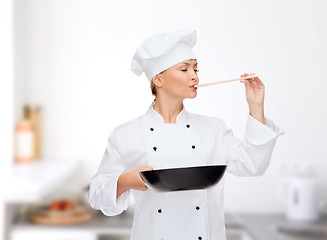 Image showing smiling female chef with pan and spoon