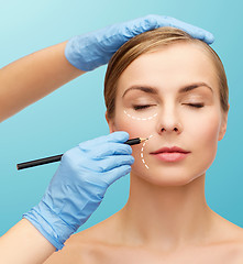 Image showing woman face and beautician hands with pencil