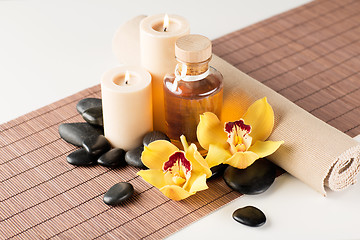 Image showing essential oil, massage stones and orchid flower