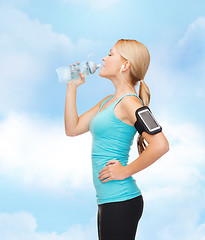 Image showing sporty woman running with smartphone and earphones