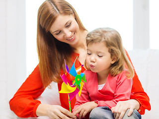 Image showing happy mother and daughter with pinwheel toy