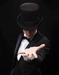 Image showing magician holding something on palm of his hand