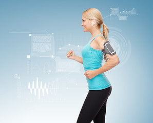 Image showing sporty woman running with smartphone and earphones