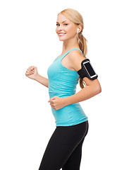 Image showing sporty woman running with smartphone and earphones