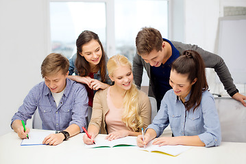 Image showing smiling students with notebooks at school