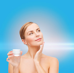 Image showing woman applying cream on her skin