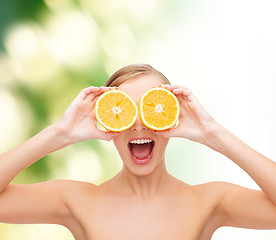 Image showing amazed young woman with orange slices
