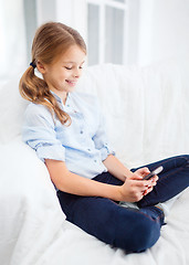 Image showing smiling girl with smartphone at home