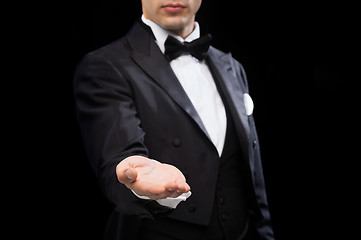 Image showing magician holding something on palm of his hand