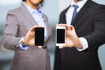 Image showing businessman and businesswoman with smartphones