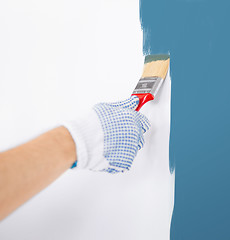 Image showing hand coloring wall with paintbrush