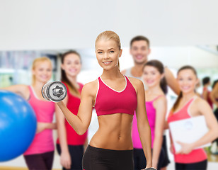 Image showing smiling woman with heavy steel dumbbells