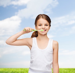 Image showing girl in blank white shirt brushing her teeth