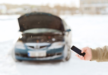 Image showing closeup of man with broken car and smartphone