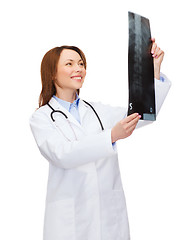 Image showing smiling female doctor looking at x-ray