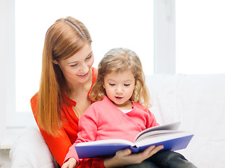 Image showing happy mother and daughter with book