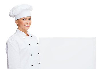 Image showing smiling female chef with white blank board