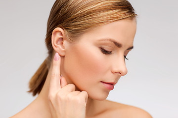 Image showing calm woman touching her ear