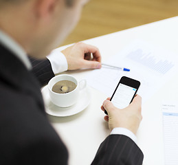 Image showing businessman with smartphone reading news