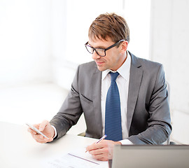 Image showing businessman working with laptop and smartphone