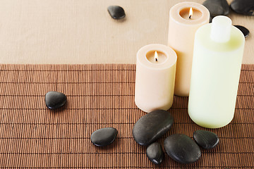 Image showing shampoo bottle, massage stones and candles