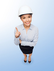 Image showing businesswoman in white helmet with finger up