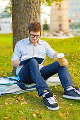 Image showing teenager reading book with take away coffee