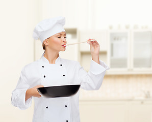 Image showing smiling female chef with pan and spoon