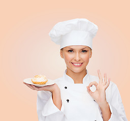 Image showing smiling female chef with cake on plate