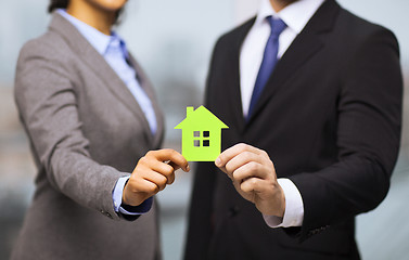 Image showing businessman and businesswoman holding green house