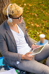 Image showing smiling male student in eyeglasses with tablet pc