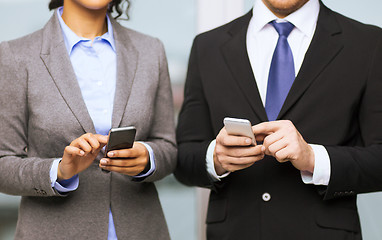 Image showing businessman and businesswoman with smartphones