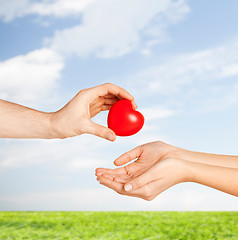 Image showing man hand giving red heart to woman