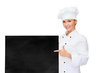 Image showing smiling female chef with white blank board