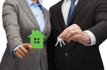 Image showing businessman and businesswoman holding green house