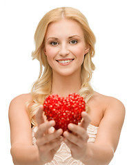 Image showing smiling woman giving small red heart