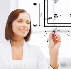 Image showing female architect drawing blueprint