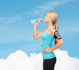 Image showing sporty woman running with smartphone and earphones