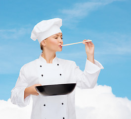 Image showing smiling female chef with pan and spoon