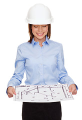 Image showing businesswoman in helmet looking at blueprint