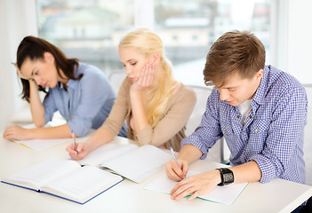 Image showing tired students with notebooks at school