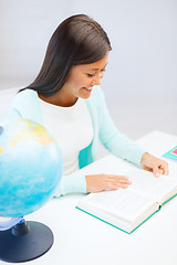 Image showing female teacher with globe and book