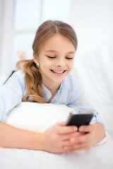 Image showing smiling girl with smartphone at home