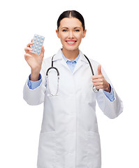 Image showing smiling female doctor with stethoscope and pills