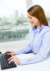 Image showing smiling businesswoman or student with computer