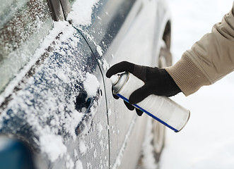 Image showing closeup of man hand with lock door de-icer