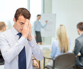 Image showing praying young buisnessman at office