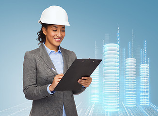 Image showing businesswoman in white helmet with clipboard