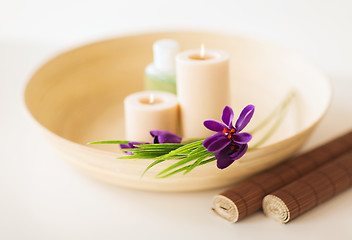 Image showing candles and iris flowers in wooden bowel and mat